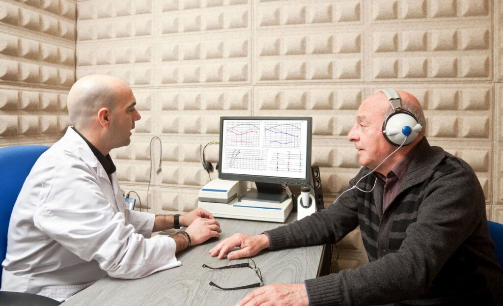 Audiology Consultant explaining hearing aid cost and digital hearing aid options to a patient in Pakistan.